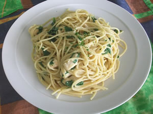 Spaguetti con pollo al curry y espinacas servido